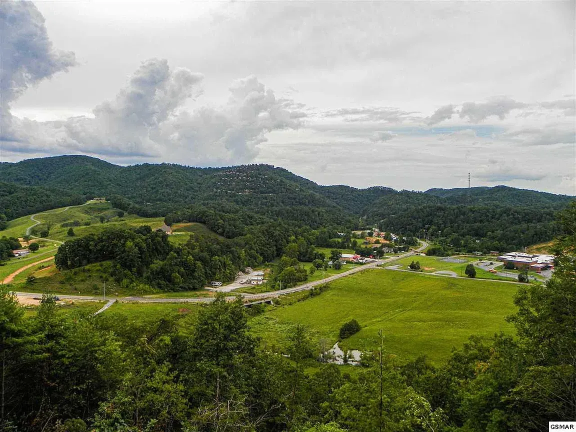 Green valley and forested Smoky Mountain ridges under summer clouds near Sevierville